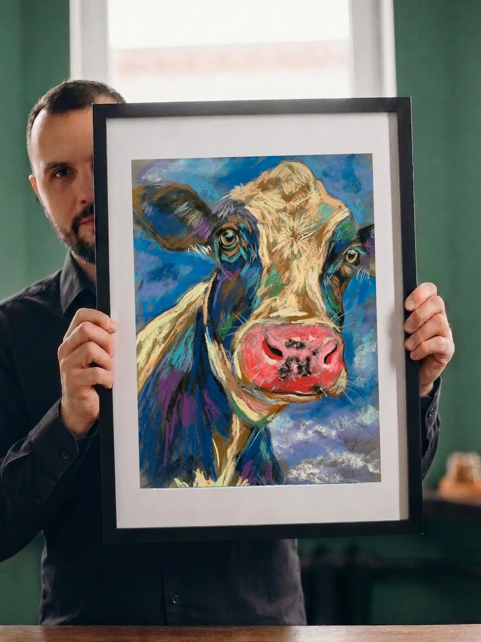 Artist holding framed expressionist soft pastel cow portrait painting with pink muzzle